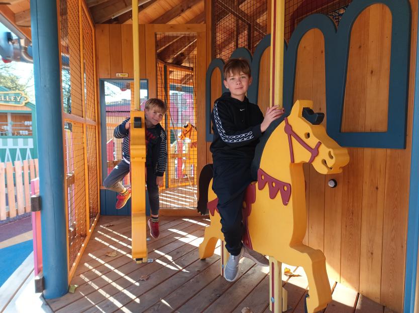 Two boys on funfair rides in an attraction without electricity or loud rides.