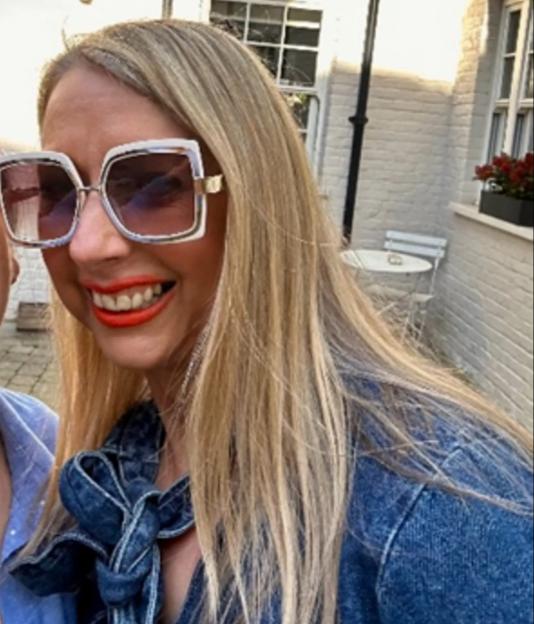 Elaine Sawyer smiling in sunglasses, wearing a denim top.