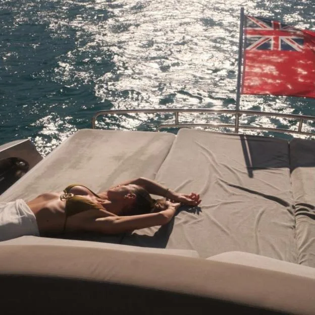 Woman in a bikini sunbathing on a yacht.
