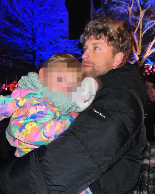 Mitch Hewer carrying a child.