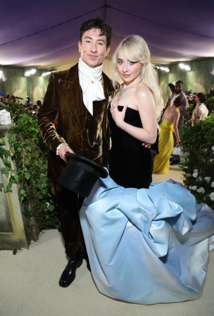 Barry Keoghan in a brown velvet suit and Sabrina Carpenter in a black strapless gown and light blue skirt attend the Met Gala.