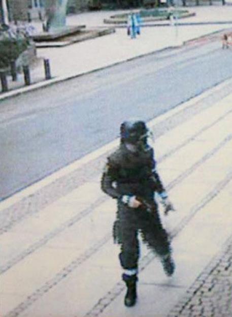 Surveillance camera still image of Anders Behring Breivik in police uniform carrying a pistol after placing a bomb in Oslo.