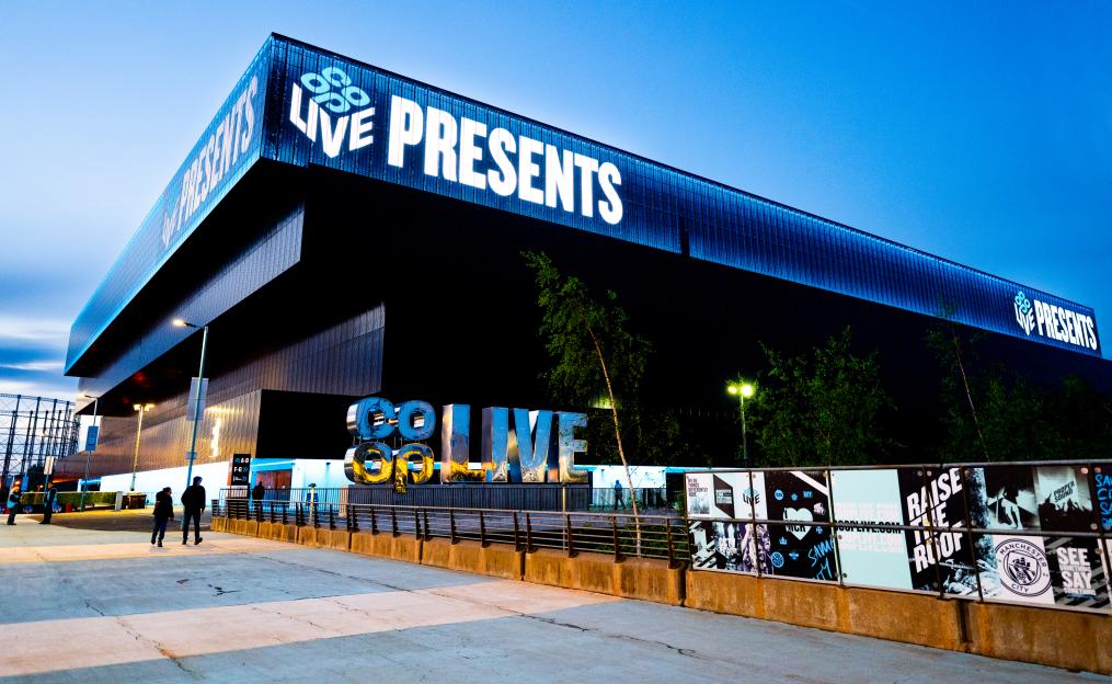 General view of the Co-op Live arena in Manchester, England, with "LIVE PRESENTS" illuminated across the top.