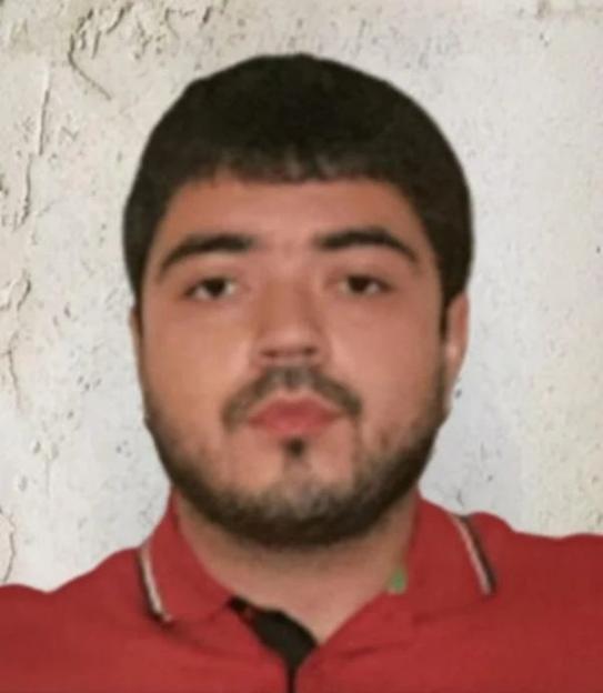 Headshot of a man with dark hair and a beard, wearing a red polo shirt.