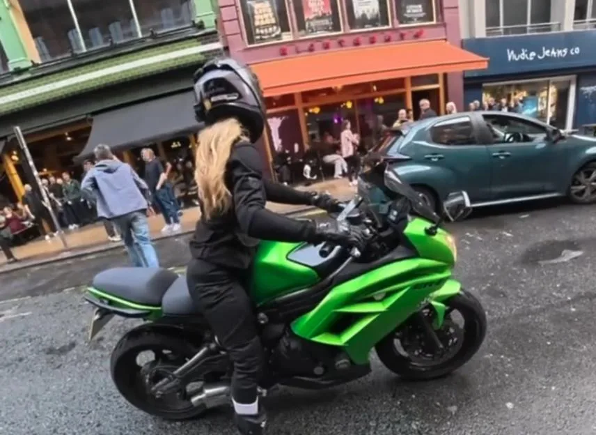 VIDEO: Motorcycle rider smacks 'inappropriate' old man jumping onto bike and grabbing her hips while she's sitting in traffic