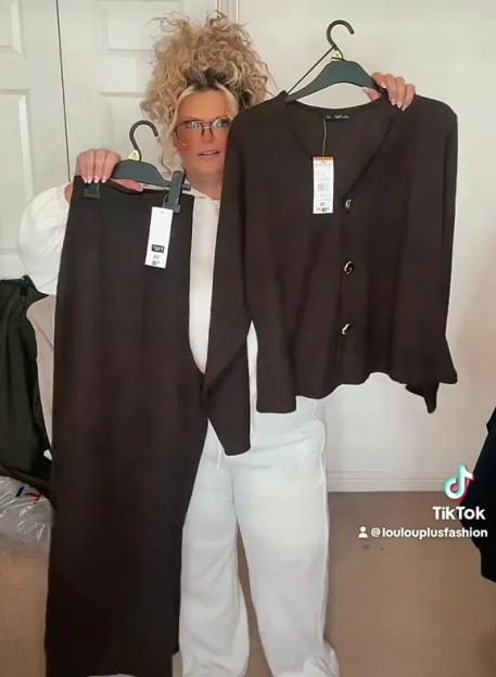 A plus-size woman holding up a dark brown skirt and a matching button-up cardigan from a Tesco F&F haul.