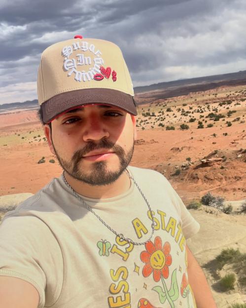 Cesar Gastelum taking a selfie with a desert landscape in the background.