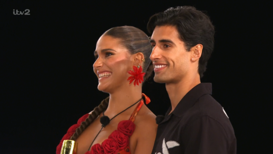 Two contestants, a woman in a red rose dress and a man in a black shirt, smiling.