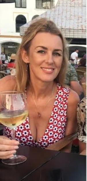 Trudi Burgess, a 56-year-old teacher, smiling while holding a glass of white wine.