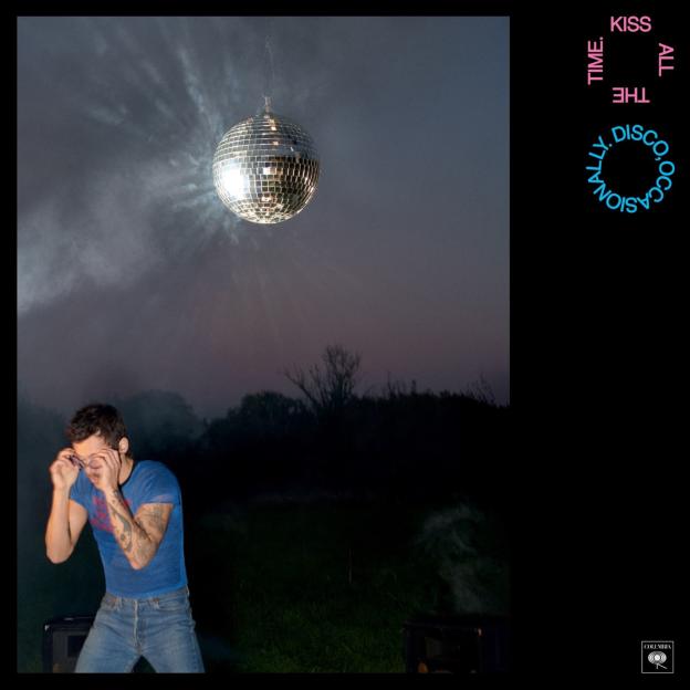 Harry Styles album cover, featuring him in jeans and a t-shirt, looking down, next to a large disco ball hanging from the sky.