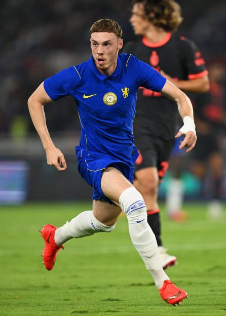A Chelsea FC player in a blue jersey with a FIFA World Champions badge running during a pre-season friendly.