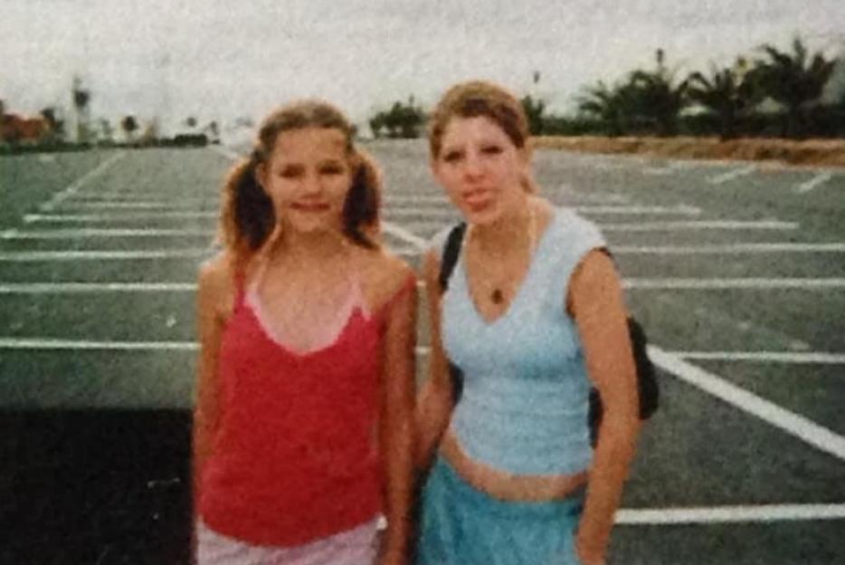 Laura Wilson and Sarah Wilson (right) posing in a parking lot.