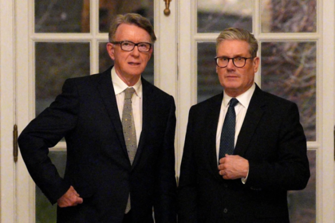 Two men in suits and glasses, standing side by side.
