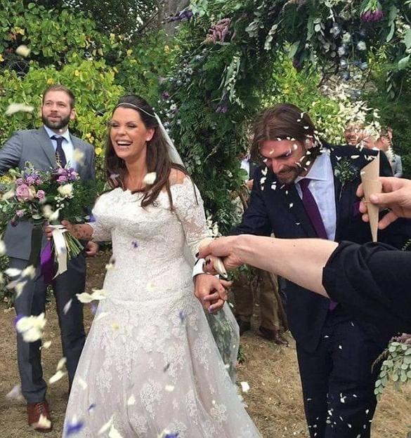 Fifi Geldof smiling at her wedding to Andrew Robertson while guests throw confetti.
