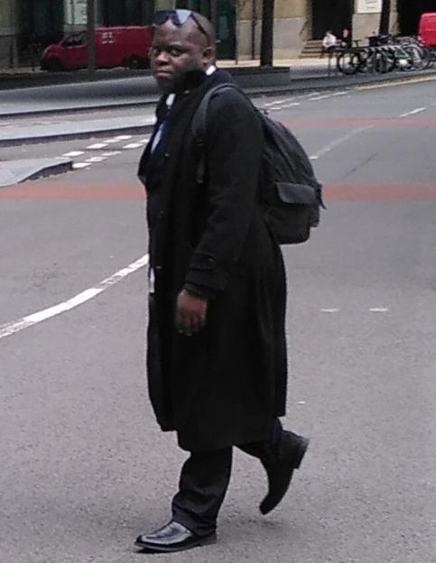 Simon Levy, a man with sunglasses perched on his head, walking on a street.