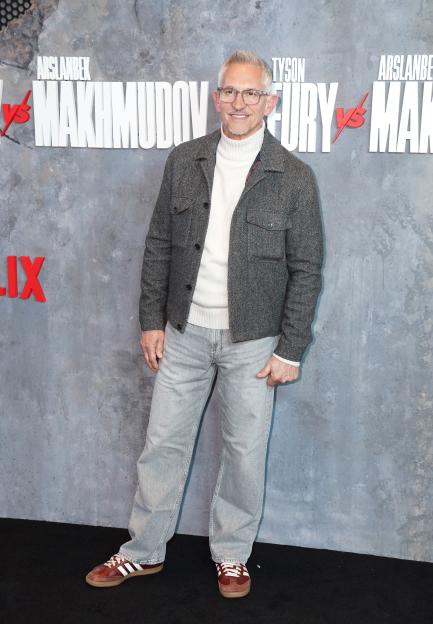 Gary Lineker smiling in front of a fight banner for Tyson Fury vs. Arslanbek Makhmudov.