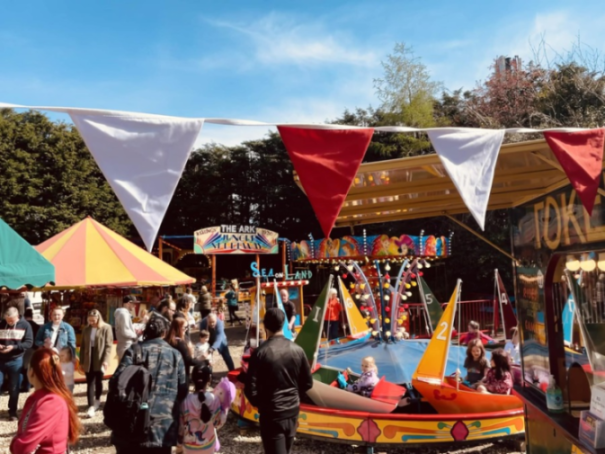 People enjoying rides and activities at a fairground.