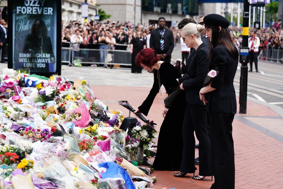 Sharon Osbourne and family lay flowers at the Black Sabbath Bridge bench in Birmingham, surrounded by other floral tributes, in memory of Ozzy Osbourne.