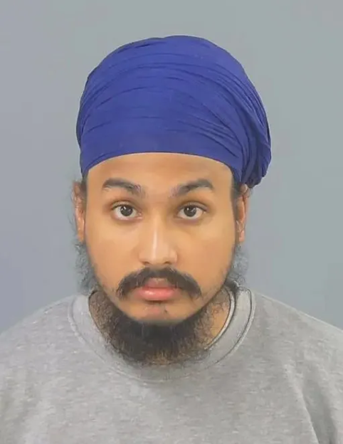 A man with a beard, mustache, and a blue turban looking forward.