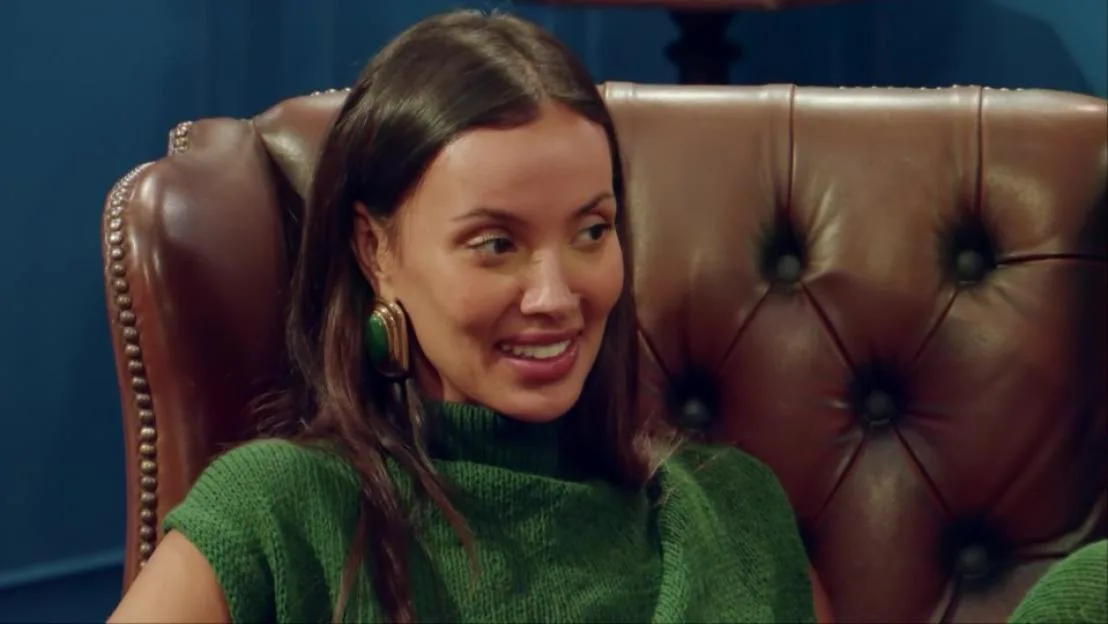 Maya Jama sitting in a leather armchair.
