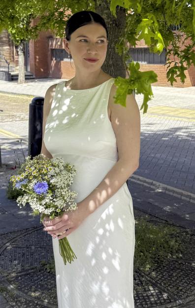 Amy Ward in her £5 wedding dress, holding a bouquet of wildflowers.