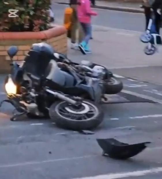 A crashed motorcycle lying on its side in a parking lot.