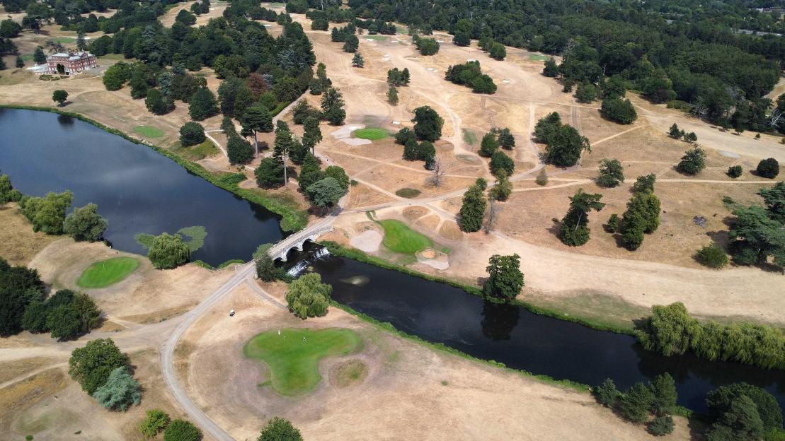 Aerial view of Brocket Hall Golf Club showing dry, parched fairways and green, irrigated putting greens next to the River Lea and Palladian Bridge.