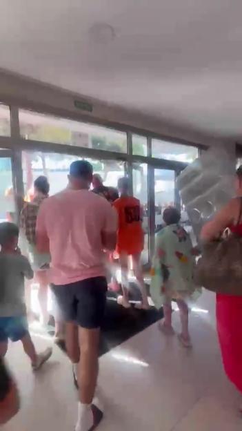 People rush through hotel doors to secure poolside loungers.