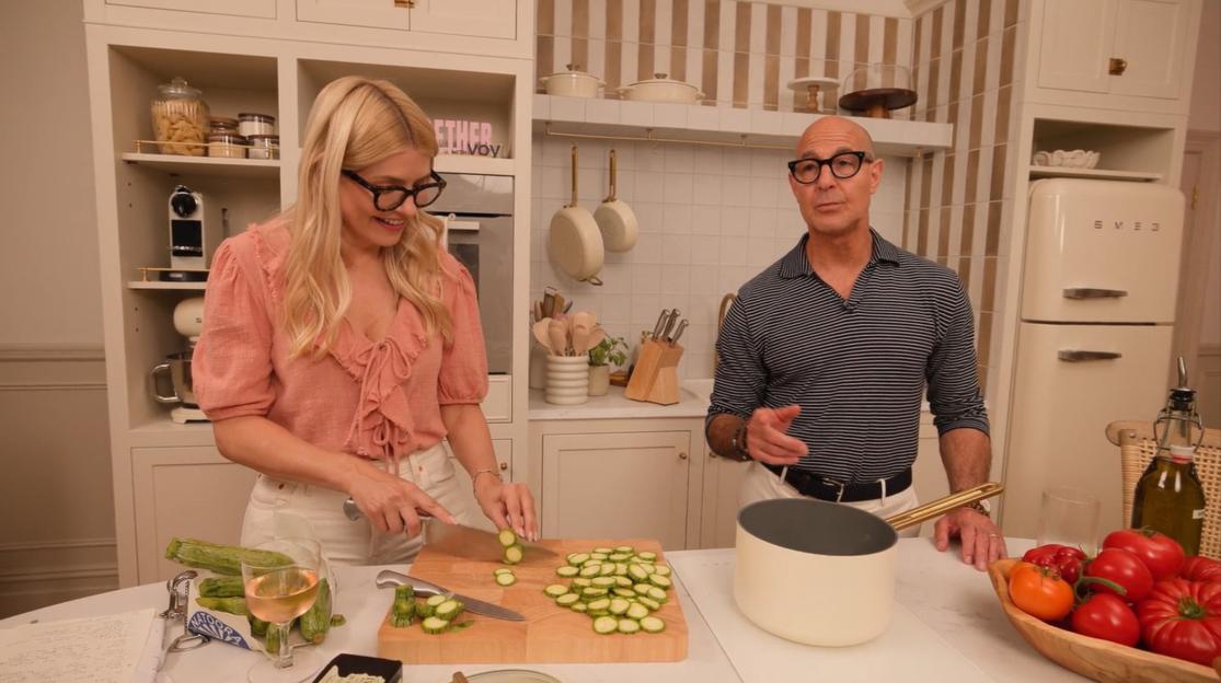 Holly Willoughby and Stanley Tucci cooking together in a kitchen.