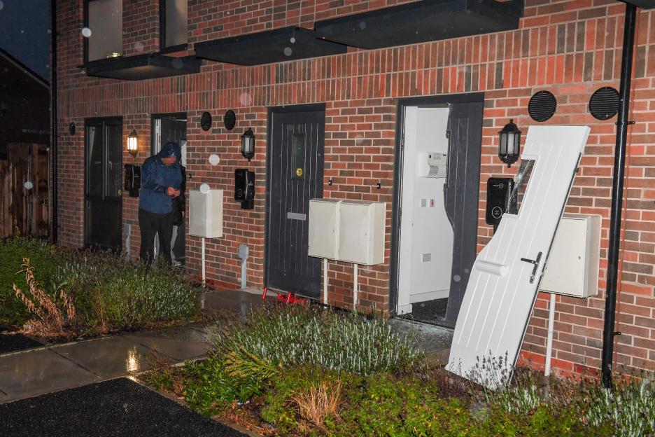 Two homes with damaged doors after a police raid.