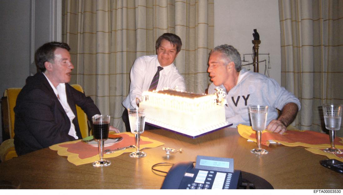 Former UK Ambassador Peter Mandelson, an unidentified man, and Jeffrey Epstein stand around a birthday cake with lit candles.