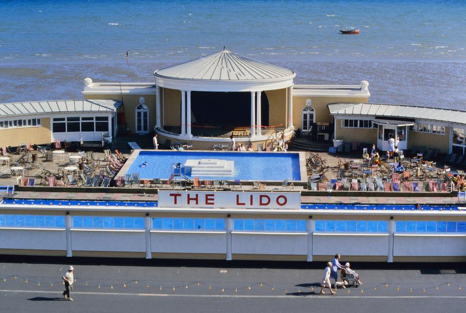 The old Worthing Lido in West Sussex, UK, with a pool and lounge chairs, by the sea.