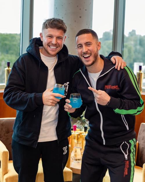 Eden Hazard and a ball boy, eleven years after a famous incident, holding blue drinks.