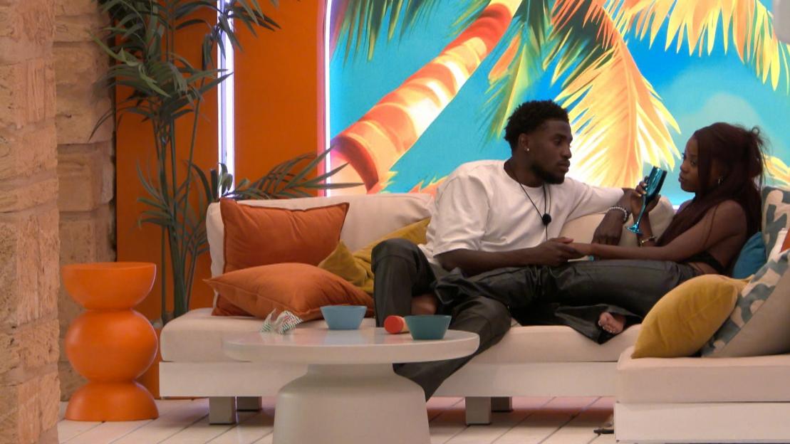 Simba Kudyiwa and Angelista sitting on a couch on the set of "Love Island."