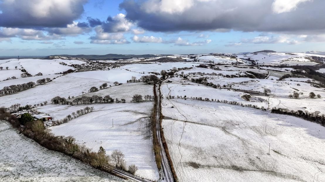 Aerial view of snow-covered fields and hills in North Wales.