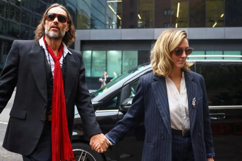 Russell Brand and his wife Laura Brand holding hands as they arrive at Southwark Crown Court in London.