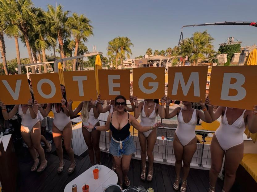 Susanna Reid posing with women holding "VOTE GMB" signs at O Beach Ibiza.