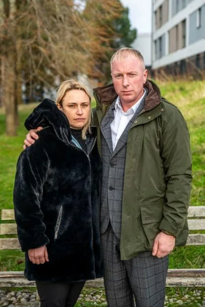 Kelly and David Kennard standing outdoors with somber expressions.