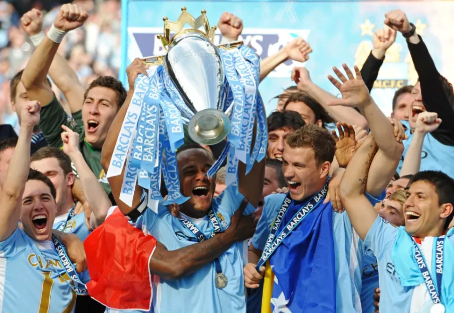 Manchester City players celebrate wildly as they lift the Premier League trophy.