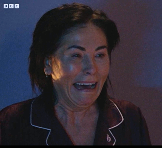 Kat Slater in pajamas, crying out in anguish.