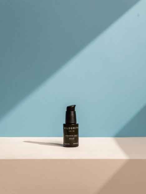 Wildsmith Skin Radiance Light Serum on a white surface with a blue background.