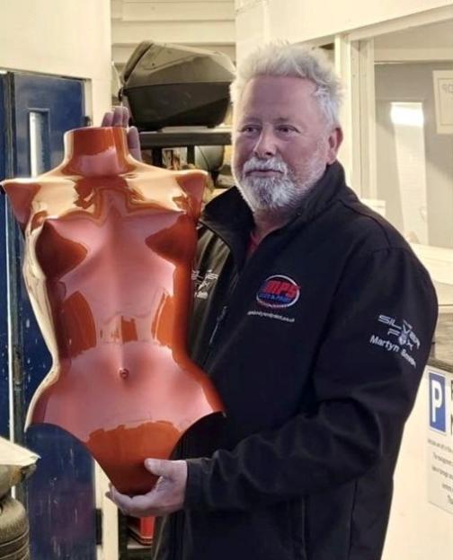 Martyn Smith holding the orange fibreglass breastplate he painted for Kim Kardashian's Met Gala outfit.