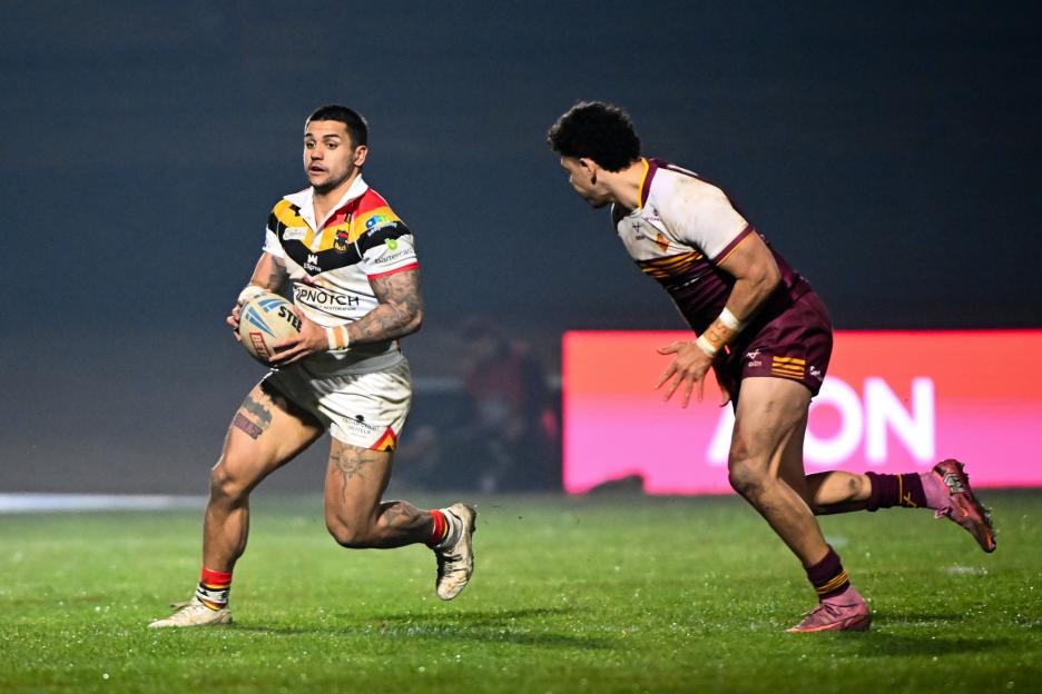 Jayden Nikorima running with a rugby ball, pursued by an opponent.