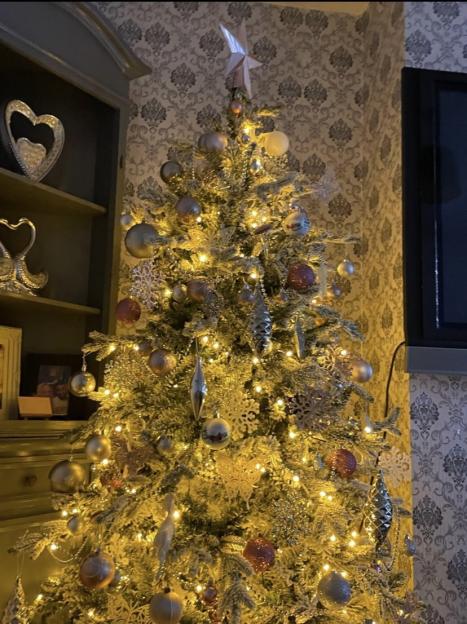 An artificial Christmas tree decorated with baubles and lights, before it caused a house fire.
