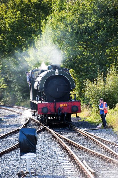 Steam train at Bodiam Station with crew.
