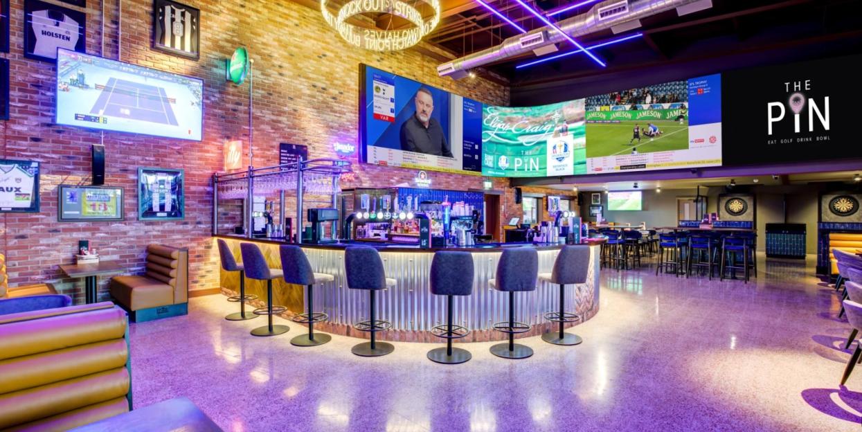 Interior of The Pin at Ramside Hall Hotel, Golf & Spa, with a large bar, multiple sports screens, and seating areas.
