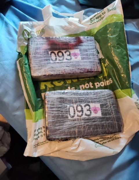 Two large wrapped packages of recovered cocaine with "093" labels.
