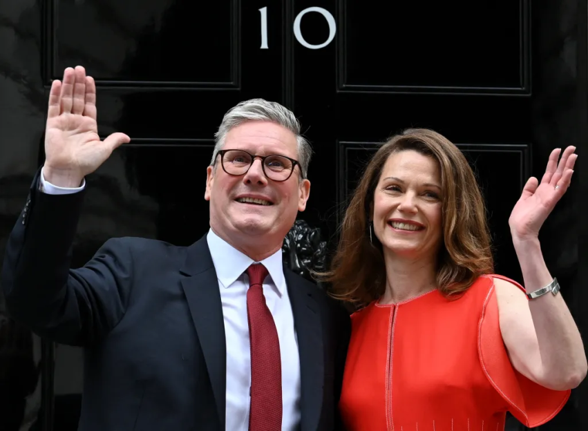 Keir Starmer and his wife, Victoria, wave from the steps of Number 10 Downing Street.
