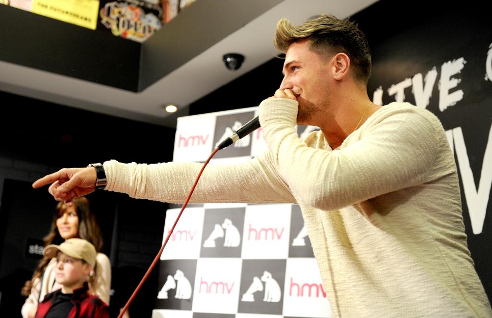 Tom Zanetti pointing and speaking into a microphone.