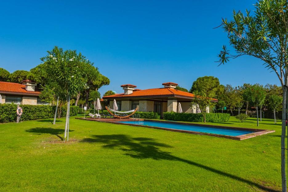Gloria Golf Resort villa with a private swimming pool, hammock, and lounge chairs.